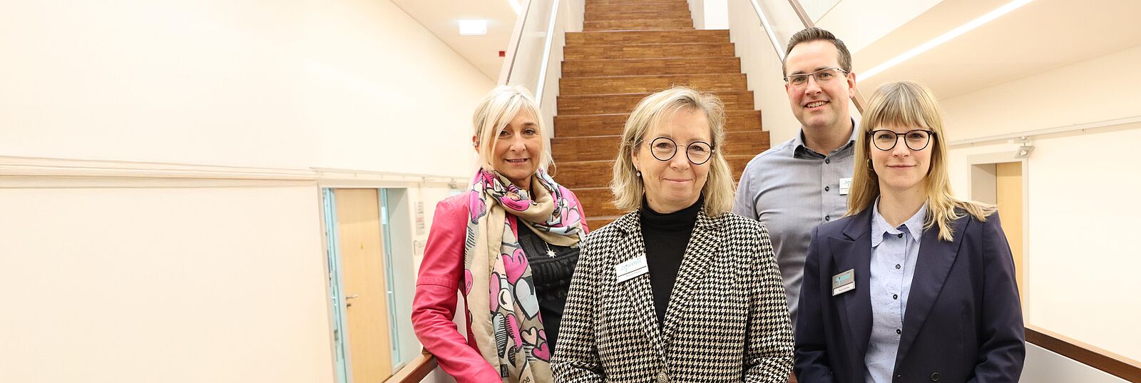 Portrait von njumii-Kundenberatern auf einer Treppe im Gebäude des Bildungszentrums (njumii)